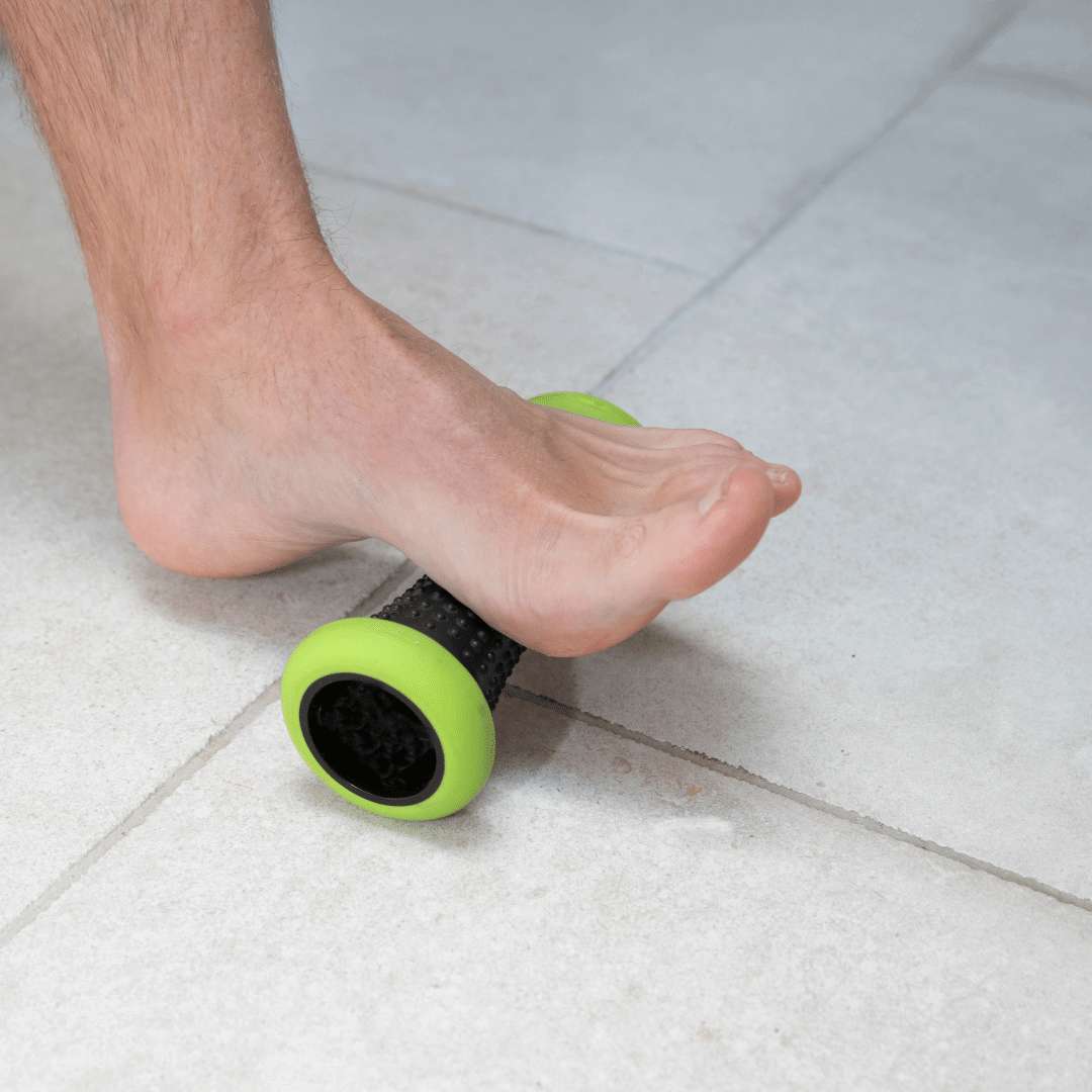 Self massage for plantar fasciitis A man using a trigger point roller to massage the bottom of his foot